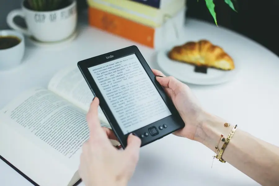Reading an eBook on a digital reader in soft, warm light